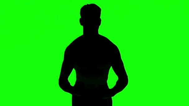 Silhuetten av en man spänna musklerna på grön skärm — Stockvideo
