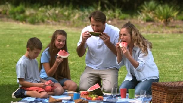 Familjen äta en vattenmelon samtidigt ha en picknick — Stockvideo