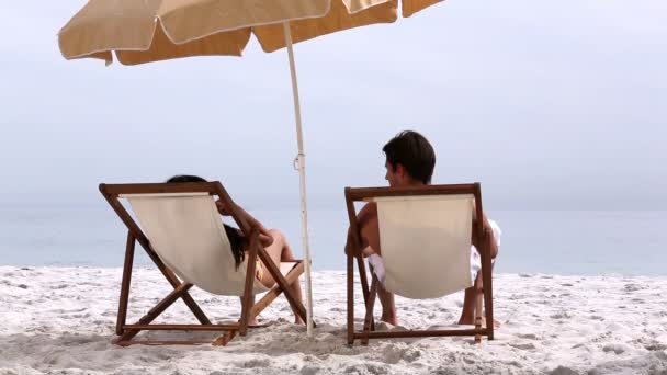Paar unter Sonnenschirm verbringt Zeit miteinander — Stockvideo