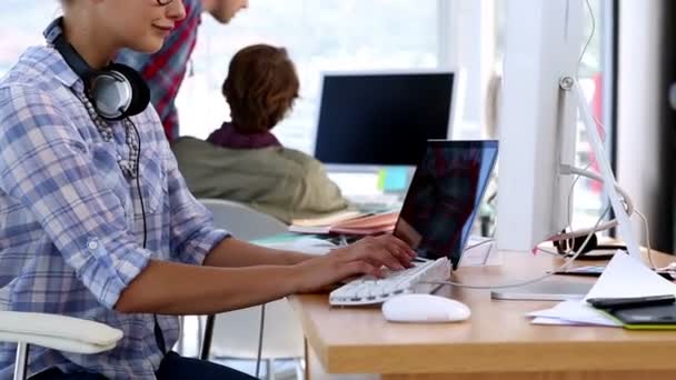 Designer working on her laptop and looking at camera — Stock Video