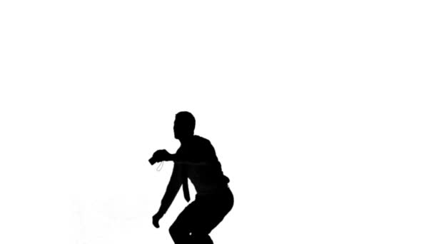 Silhouette of a jumping man turning on white background — Stock Video