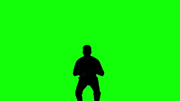 Силуэт человека, прыгающего с поднятыми ногами на зеленом экране — стоковое видео
