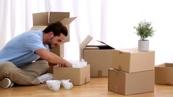 Attractive man opening his moving boxes — Stock Video