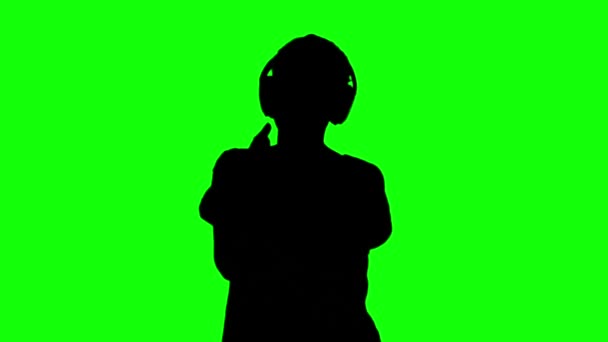 Silhouette of woman listening to music on green screen — Stock Video