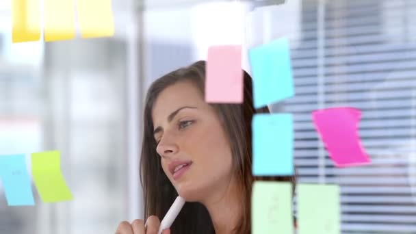 Mujer escribiendo en nota adhesiva — Vídeos de Stock