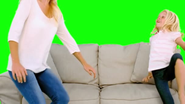 Mother and daughter jumping on the sofa on green screen — Stock Video