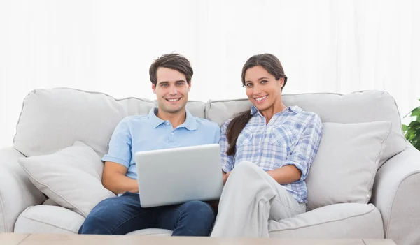 Pareja relajante con un ordenador portátil — Foto de Stock