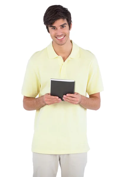 Hombre sonriente sosteniendo cuaderno negro — Foto de Stock