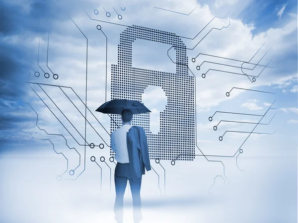 Businessman under an umbrella looking at a big padlock — Stock Photo, Image