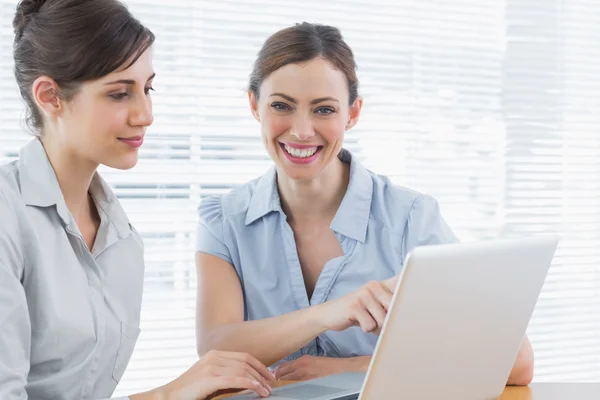 Duas empresárias felizes trabalhando no laptop juntas — Fotografia de Stock