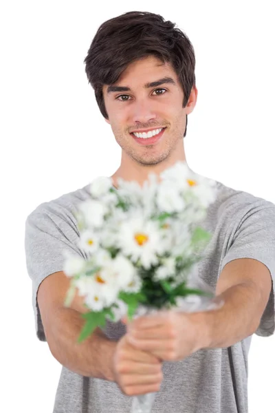 Young man offering a flower bouquet — Stock Photo, Image