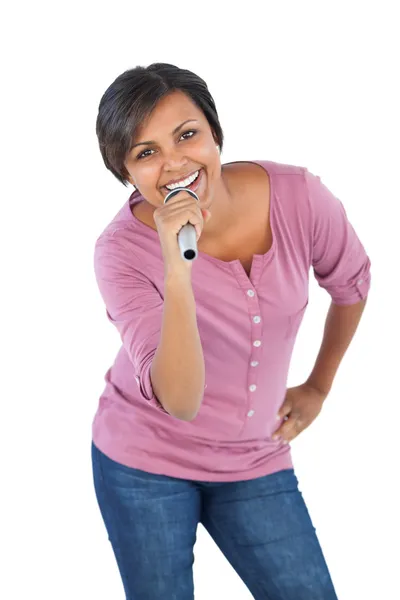 Mujer sonriente sosteniendo micrófono para cantar — Foto de Stock