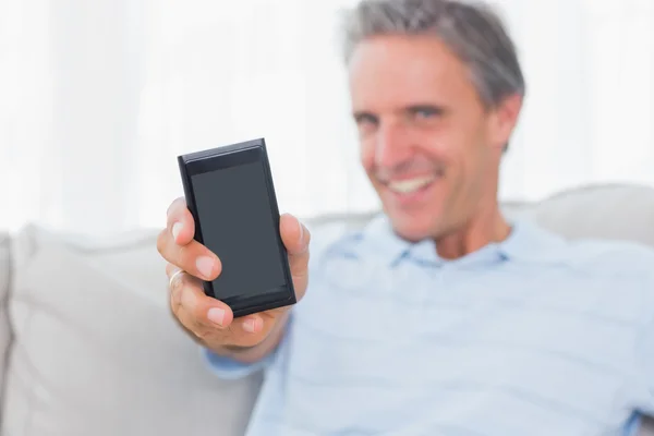 Hombre mostrando smartphone a cámara —  Fotos de Stock