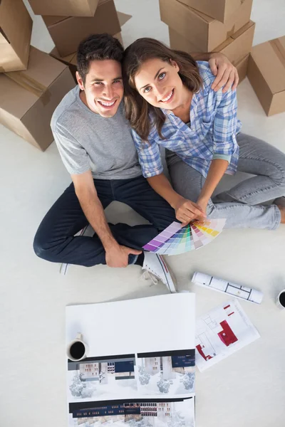 Visão geral de um homem e sua esposa segurando planos de casa — Fotografia de Stock