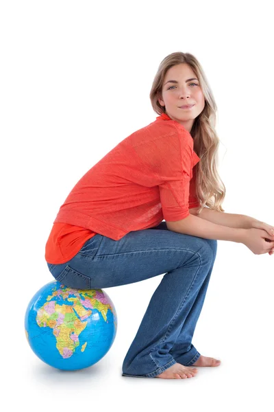 Vrouw zitten op een wereldbol — Stockfoto