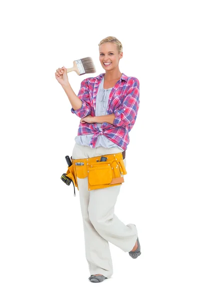Blonde standing while holding a paint brush — Stock Photo, Image