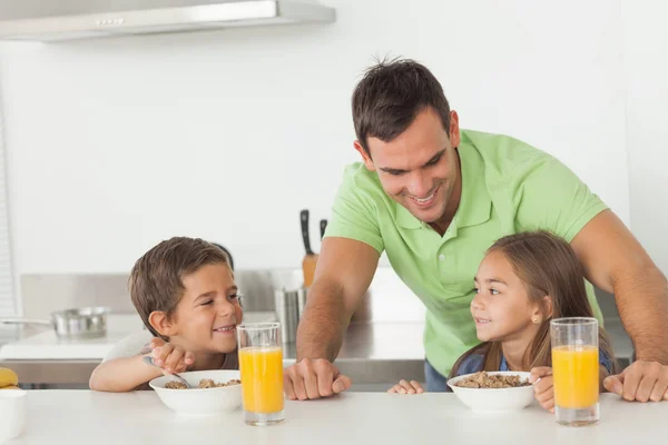 Vader aan zijn kinderen chatten terwijl ze bij het ontbijt ondervindt — Stockfoto