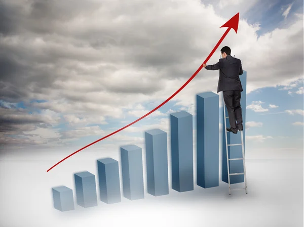 Businessman drawing a red arrow over a growing chart — Stock Photo, Image