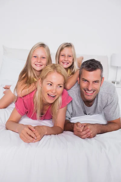 Eltern liegen mit ihren Zwillingen im Bett — Stockfoto