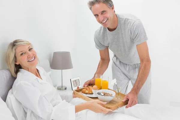 Considerate man giving breakfast in bed to his partner — Stock Photo, Image