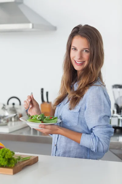Жінка на кухні тримає салатну чашу — стокове фото