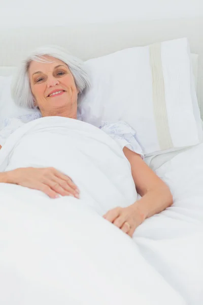 Vrouw rustend in bed — Stockfoto