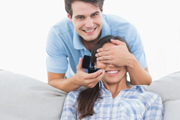 Man hiding his girlfriends eyes and offering her an engagement r — Stock Photo, Image