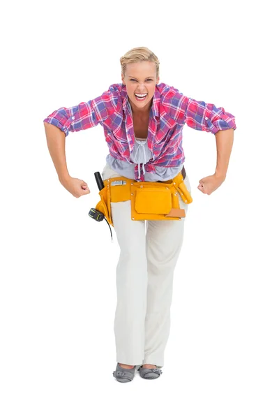 Ξανθιά γυναίκα τεντώσετε όπλων που φοράει ζώνη εργαλείων — Φωτογραφία Αρχείου