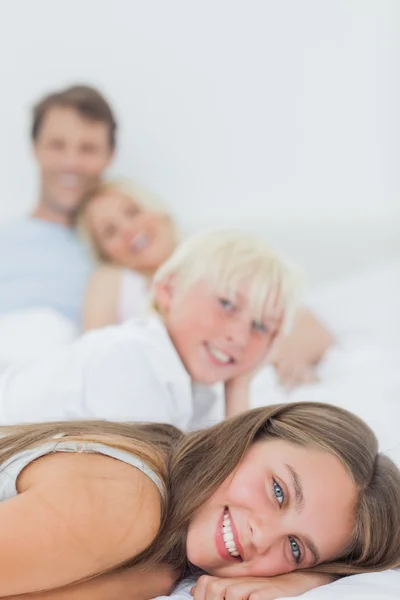 Frères et sœurs souriants couchés sur le lit — Photo