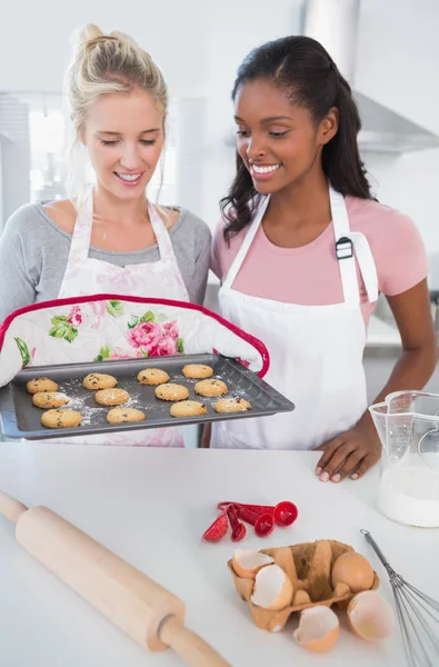 Usmívající se žena ukazující čerstvě pečené cookies k příteli — Stock fotografie