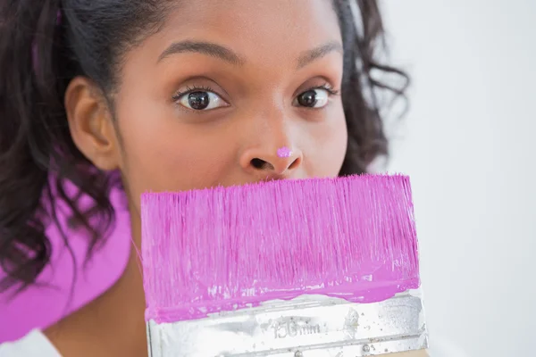 Mooie vrouw met penseel met verf op haar neus — Stockfoto