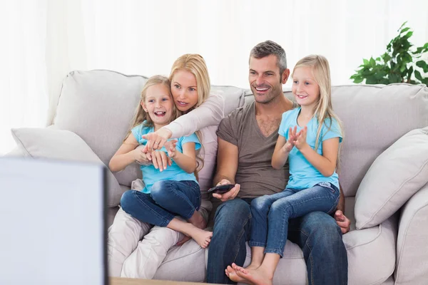 Niedliche Zwillinge und Eltern vor dem Fernseher — Stockfoto