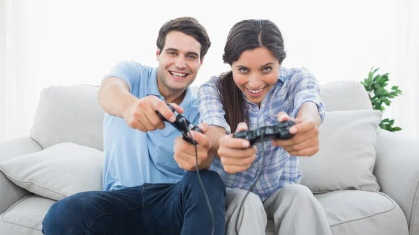 情侣坐在沙发上玩视频游戏 — 图库照片