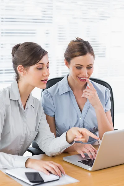 Zufriedene Geschäftsfrauen, die gemeinsam an einem Laptop arbeiten — Stockfoto