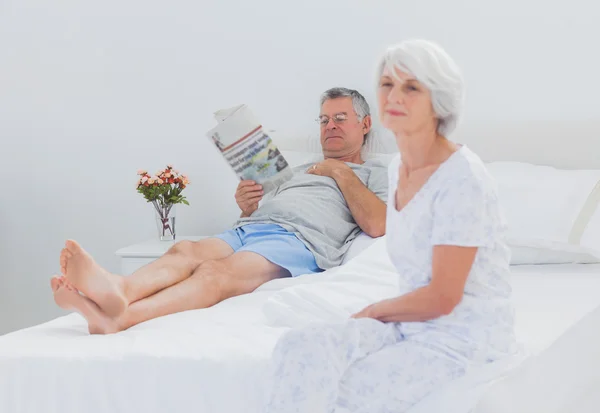Mature woman sitting on bed — Stock Photo, Image