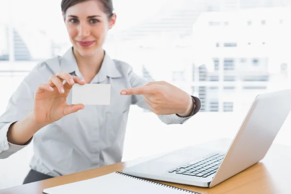 Young businesswoman pointing to blank business card — Stock Photo, Image