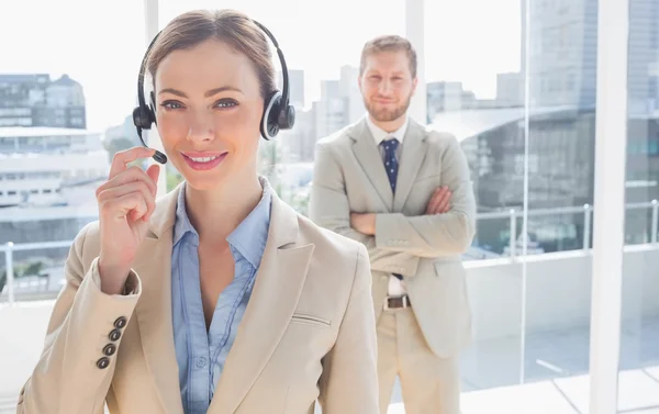 Call centre worker standing with colleague behind her — Stock Photo, Image