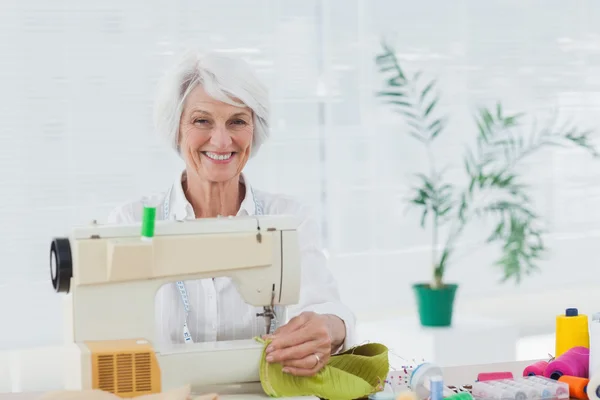 Fröhliche Frau mit der Nähmaschine zu Hause — Stockfoto