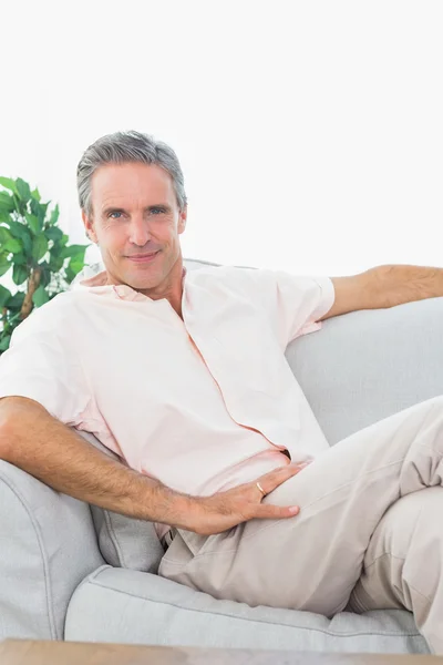 Homem feliz relaxando em seu sofá — Fotografia de Stock