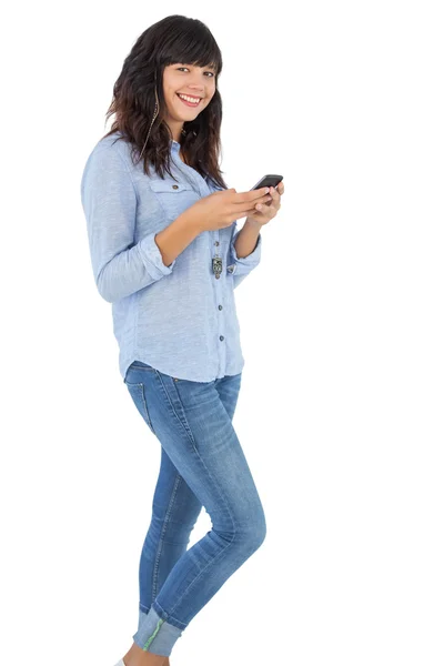 Morena feliz com seu telefone celular enviando uma mensagem — Fotografia de Stock