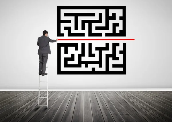 Businessman standing on a ladder drawing red line through qr cod — Stock Photo, Image