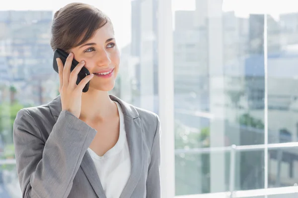 Empresária sorrindo e chamando pelo telefone — Fotografia de Stock