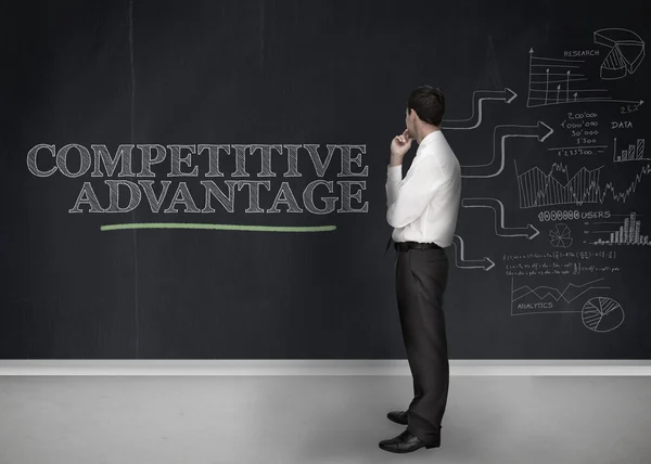 Businessman standing in front of a blackboard — Stock Photo, Image