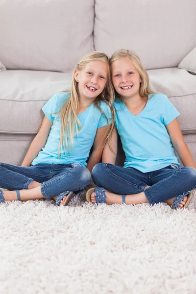 Young twins sitting on a carpet — Stock Photo, Image