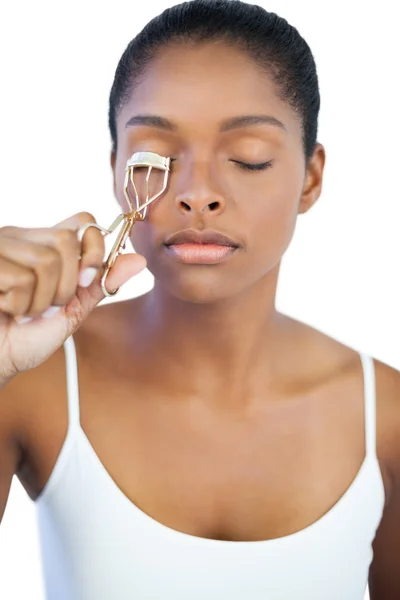 Giovane donna utilizzando bigodino per le ciglia — Foto Stock