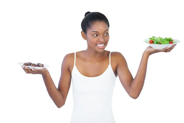 Vrolijke vrouw beslissen om te eten gezond of niet — Stockfoto