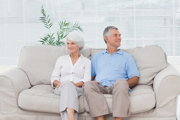 Starší pár sedí na pohovce — Stock fotografie