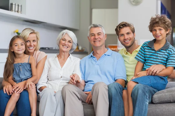 Extended family sitting on couch in living room — Stock Photo, Image
