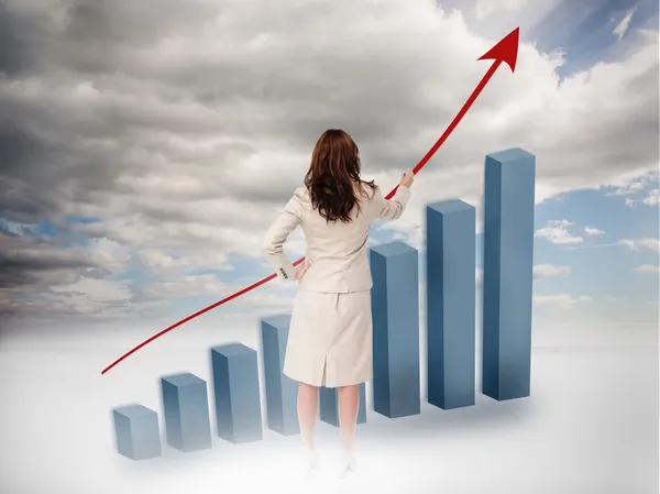 Empresária desenhando uma seta vermelha sobre um gráfico crescente — Fotografia de Stock