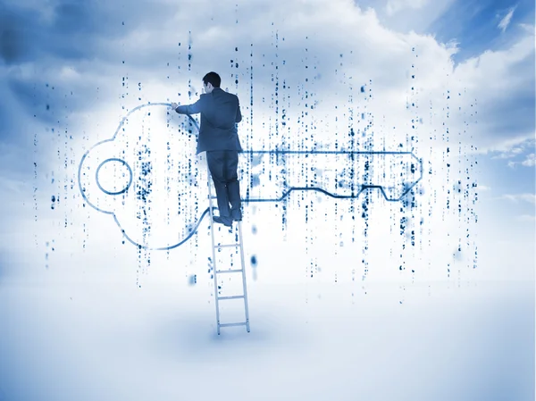 Businessman on a ladder drawing a key — Stock Photo, Image
